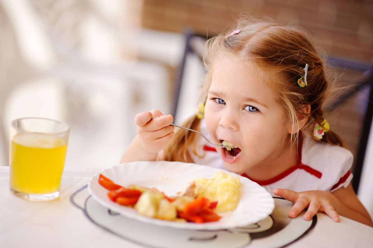 Little girl having breakfast indoors